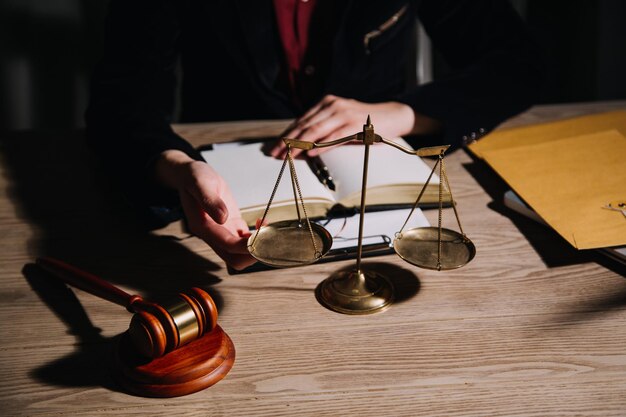 Justice and law conceptMale judge in a courtroom with the gavel working with computer and docking keyboard eyeglasses on table in morning light