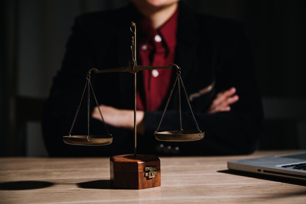 Justice and law conceptMale judge in a courtroom with the gavel working with computer and docking keyboard eyeglasses on table in morning light