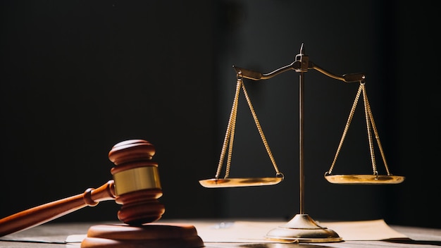 Justice and law conceptMale judge in a courtroom with the gavel working with computer and docking keyboard eyeglasses on table in morning light