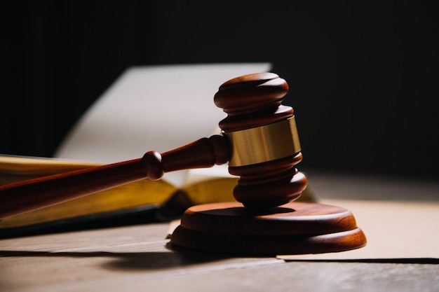 Justice and law conceptMale judge in a courtroom with the gavel working with computer and docking keyboard eyeglasses on table in morning light