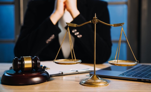 Justice and law conceptMale judge in a courtroom with the gavel working with computer and docking keyboard eyeglasses on table in morning light