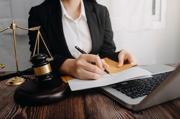 Justice and law conceptMale judge in a courtroom with the gavel working with computer and docking keyboard eyeglasses on table in morning light