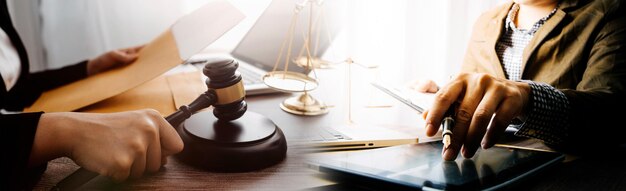 Justice and law conceptMale judge in a courtroom with the gavel working with computer and docking keyboard eyeglasses on table in morning light