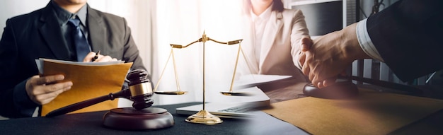 Justice and law conceptMale judge in a courtroom with the gavel working with computer and docking keyboard eyeglasses on table in morning light