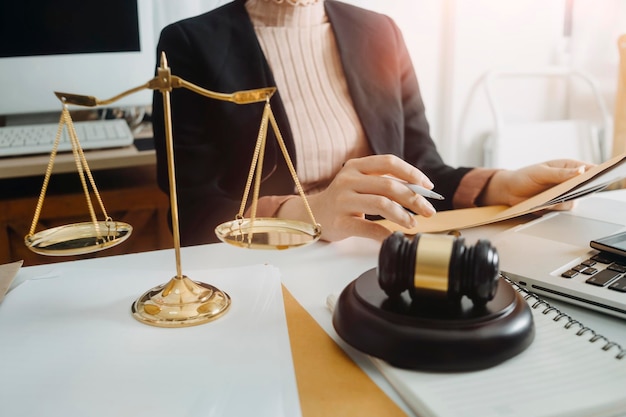 Justice and law conceptMale judge in a courtroom with the gavel working with computer and docking keyboard eyeglasses on table in morning light