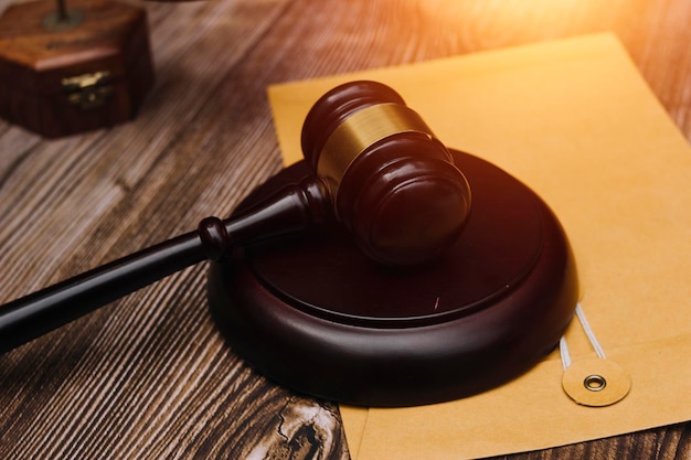 Justice and law conceptMale judge in a courtroom with the gavel working with computer and docking keyboard eyeglasses on table in morning light