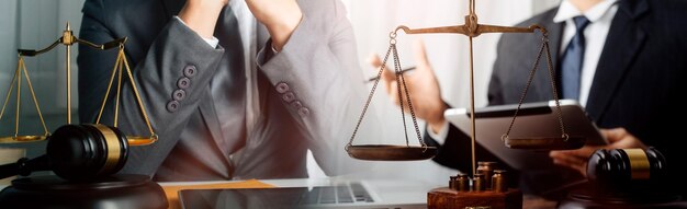 Justice and law conceptMale judge in a courtroom with the gavel working with computer and docking keyboard eyeglasses on table in morning light