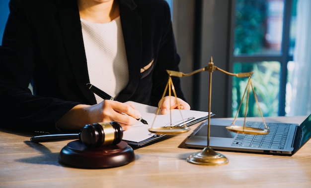 Justice and law conceptMale judge in a courtroom with the gavel working with computer and docking keyboard eyeglasses on table in morning light