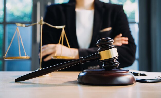 Justice and law conceptMale judge in a courtroom with the gavel working with computer and docking keyboard eyeglasses on table in morning light