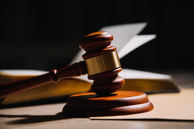 Justice and law conceptMale judge in a courtroom with the gavel working with computer and docking keyboard eyeglasses on table in morning light