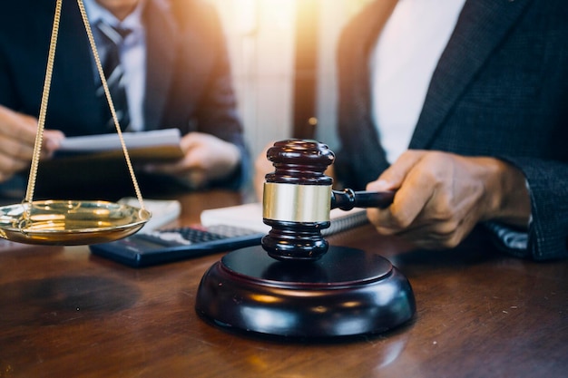 Justice and law conceptMale judge in a courtroom with the gavel working with computer and docking keyboard eyeglasses on table in morning light