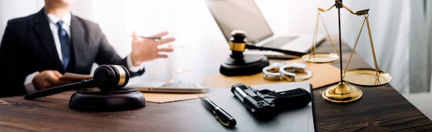 Justice and law conceptMale judge in a courtroom with the gavel working with computer and docking keyboard eyeglasses on table in morning light