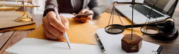 Justice and law conceptMale judge in a courtroom with the gavel working with computer and docking keyboard eyeglasses on table in morning light