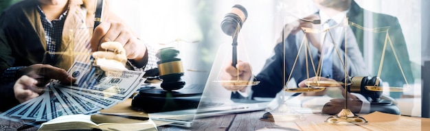 Justice and law conceptMale judge in a courtroom with the gavel working with computer and docking keyboard eyeglasses on table in morning light