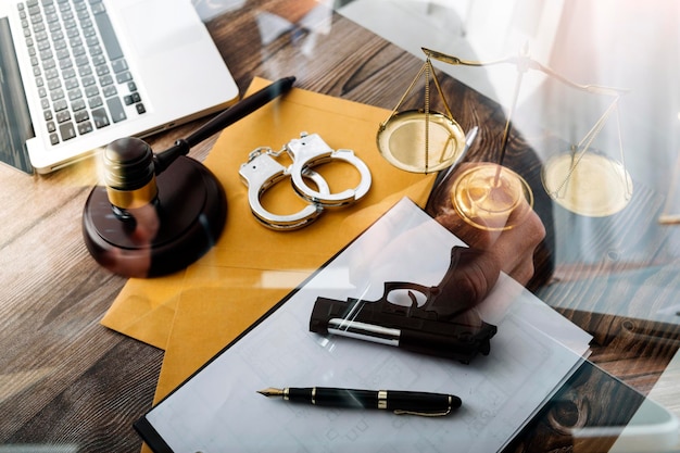 Justice and law conceptMale judge in a courtroom with the gavel working with computer and docking keyboard eyeglasses on table in morning light