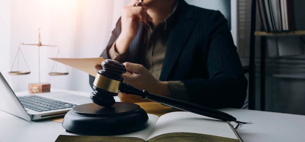 Justice and law conceptMale judge in a courtroom with the gavel working with computer and docking keyboard eyeglasses on table in morning light