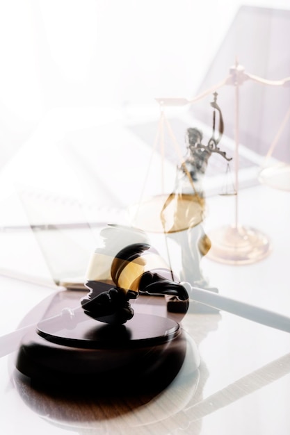 Justice and law conceptMale judge in a courtroom with the gavel working with computer and docking keyboard eyeglasses on table in morning light