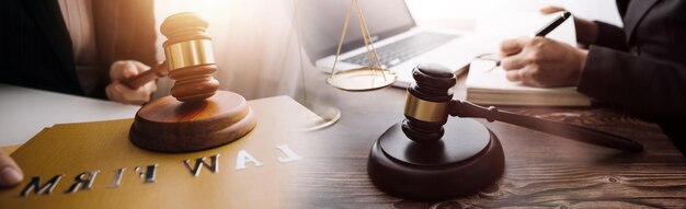 Justice and law conceptMale judge in a courtroom with the gavel working with computer and docking keyboard eyeglasses on table in morning light