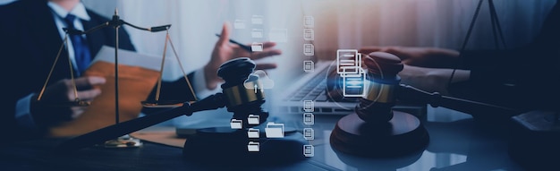 Justice and law conceptMale judge in a courtroom with the gavel working with computer and docking keyboard eyeglasses on table in morning light