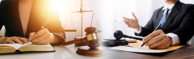 Justice and law conceptMale judge in a courtroom with the gavel working with computer and docking keyboard eyeglasses on table in morning light