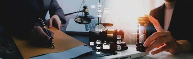 Justice and law conceptMale judge in a courtroom with the gavel working with computer and docking keyboard eyeglasses on table in morning light