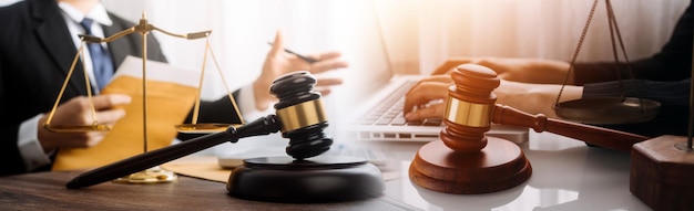 Justice and law conceptMale judge in a courtroom with the gavel working with computer and docking keyboard eyeglasses on table in morning light