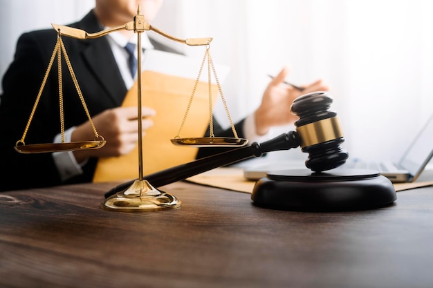 Justice and law conceptMale judge in a courtroom with the gavel working with computer and docking keyboard eyeglasses on table in morning light