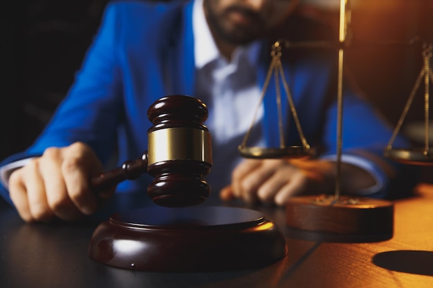 Justice and law conceptmale lawyer in the office with brass scale on wooden table