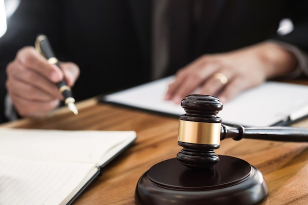 Justice lawyer/ judge gavel working with legal documents in a court room