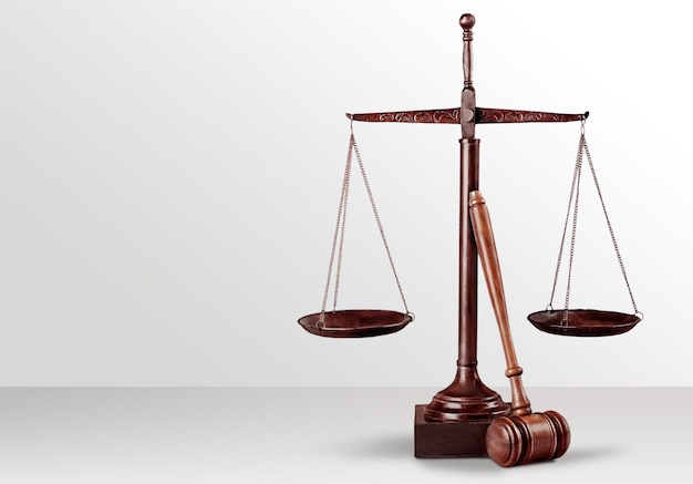 Justice Scales and wooden gavel on light background