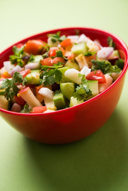 Kachumber OR Indian Green Salad also known as Koshimbir. Served in a bowl over moody background. Selective focus