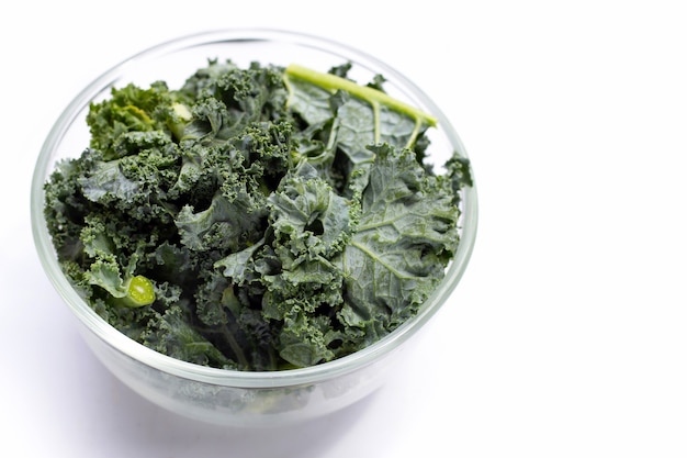 Kale leaves in glass bowl on white background.