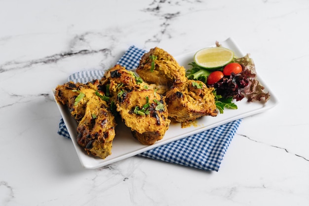 Kali Mirchi or black pepper beef Kebab with lime in a dish isolated on napkin side view on grey background