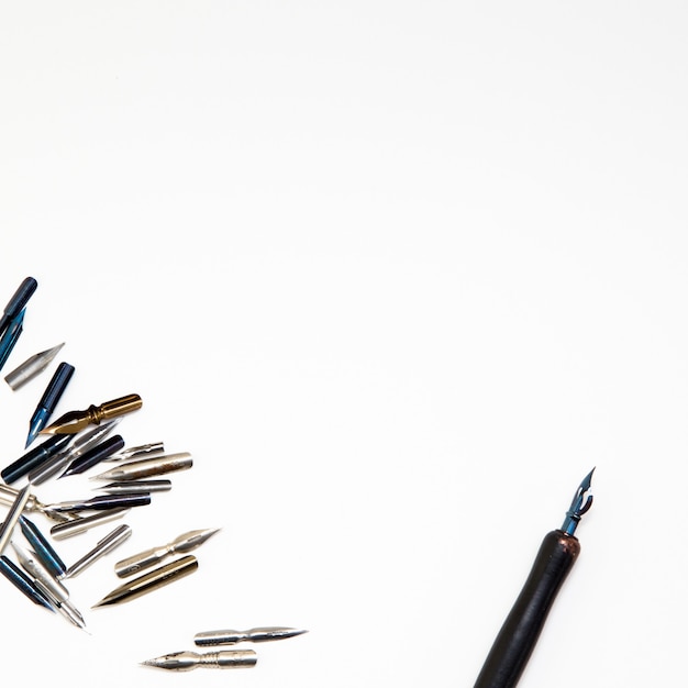 Photo kaliograph workplace. calligraphy pens and pen on a white background. top view. close-up, mockup.