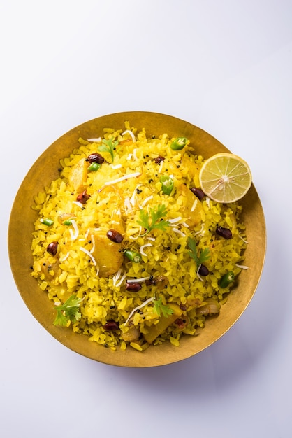 Kande Pohay OR Aloo Poha is a popular Indian breakfast recipe made using Flattened rice, usually served with hot tea. Served in a bowl over . Selective focus