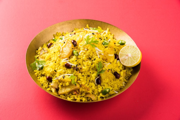 Kande Pohay OR Aloo Poha is a popular Indian breakfast recipe made using Flattened rice, usually served with hot tea. Served in a bowl over . Selective focus