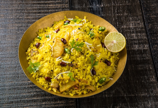 Kande Pohay OR Aloo Poha is a popular Indian breakfast recipe made using Flattened rice, usually served with hot tea. Served in a bowl over . Selective focus