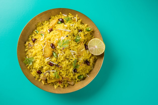 Kande Pohay OR Aloo Poha is a popular Indian breakfast recipe made using Flattened rice, usually served with hot tea. Served in a bowl over . Selective focus