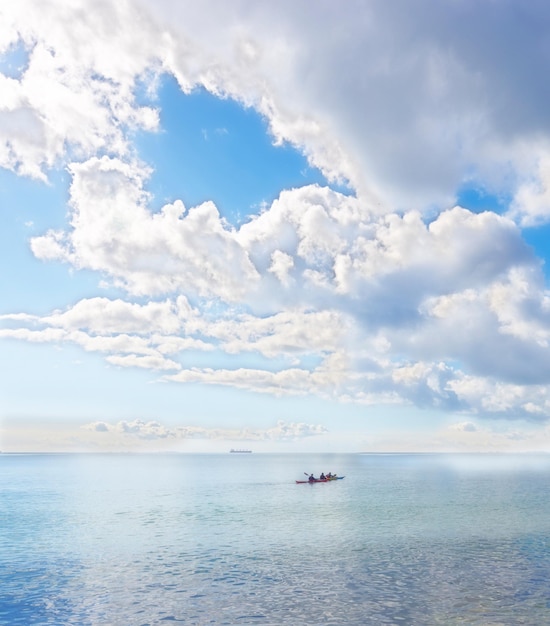 Kayak canoe or rowboat on a beautiful ocean beach or sea with clouds in sky background outdoors Scenic view of calm waves of water at a coast with relaxing peaceful and bright landscape in nature