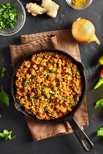 Photo keema curry in pan over black stone background indian and pakistani style dish top view flat lay