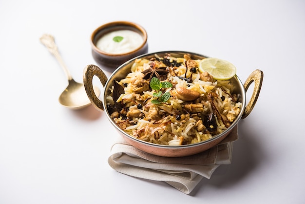 Keema or Kheema Biryani - Fragrant and spicy minced lamb or goat or chicken cooked in range of aromatic spices with basmati rice. served in a karahi with curd. selective focus