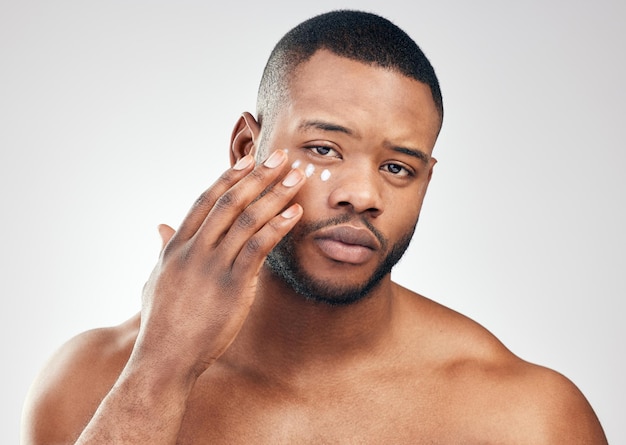 Keep your skin hydrated protected and conditioned Studio portrait of a handsome young man applying moisturiser to his face against a white background