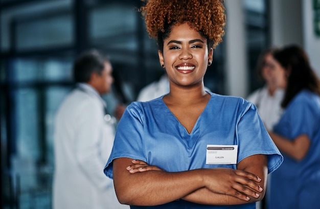 Keeping your health in expert hands Portrait of a confident young doctor working in a hospital with her colleagues in the background