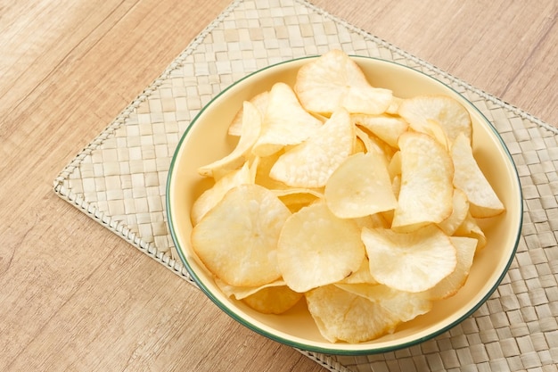 Keripik Singkong or Cassava Chips, Indonesian traditional snack. Served in bowl on wooden background