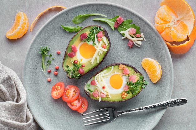 Keto diet dish: Avocado boats with ham cubes, quail eggs and cheese, top lay