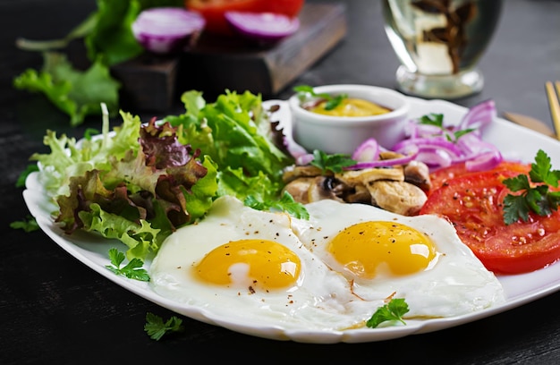 Ketogenic food Fried eggs mushrooms and sliced tomatoes Keto paleo breakfast