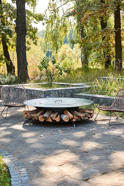 Kettle Grill Pit with Cast Iron Grid with flames . Round table-cooking surface. Hot BBQ on Backyard