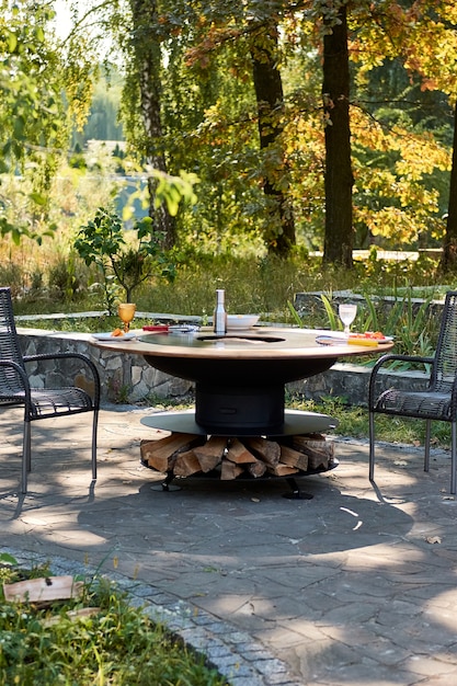 Kettle Grill Pit with Cast Iron Grid with flames . Round table-cooking surface. Hot BBQ on Backyard