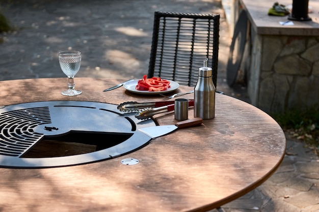 Kettle Grill Pit with Cast Iron Grid with flames . Round table-cooking surface. Hot BBQ on Backyard