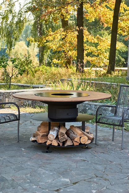 Kettle Grill Pit with Cast Iron Grid with flames . Round table-cooking surface. Hot BBQ on Backyard